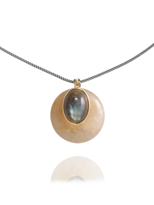 Close-up detail of the MOUNSER Aarnio Pendant in Olive Oil showing the domed yellow jade disc, oval labradorite cabochon, and 14k gold-plated brass setting on twisted cord with reflection.