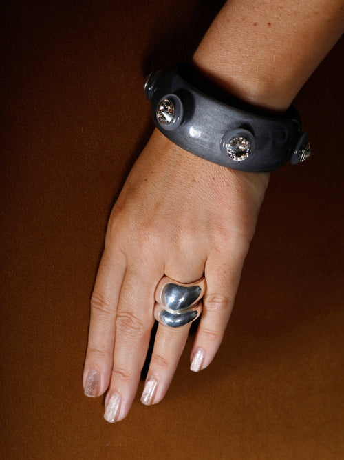 Close-up of the MOUNSER Ambrosia Bangle highlighting vivid Austrian crystals set into polished gray resin.