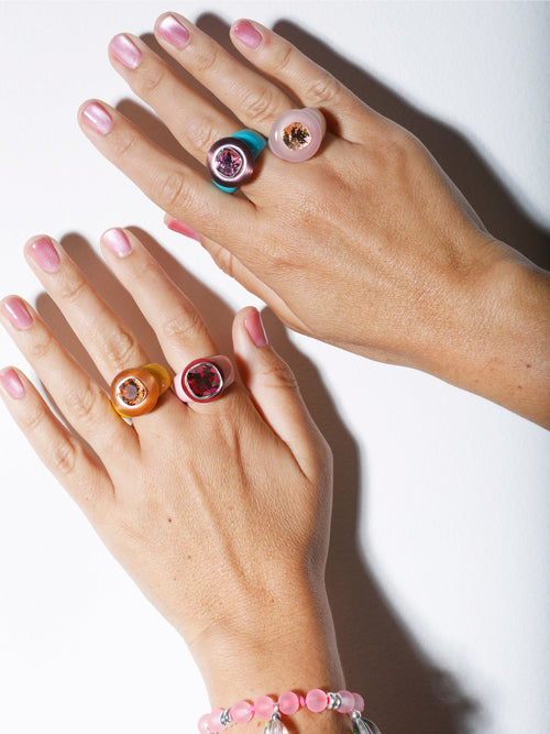 Hand shot of MOUNSER Bliss Ring in Blush a delicate and minimal acrylic cocktail ring in a jewel toned palette with a Swarovski crystal gemstone.  