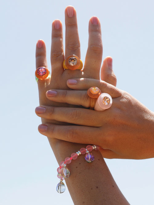 Outdoor shot of MOUNSER Bliss Ring in Blush a delicate and minimal acrylic cocktail ring in a jewel toned palette with a Swarovski crystal gemstone.  