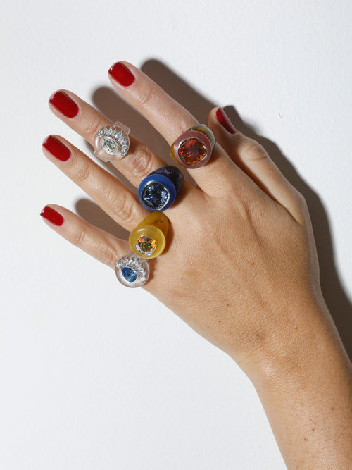 Studio shot of MOUNSER Bliss Ring in Honey a delicate and minimal acrylic cocktail ring in a jewel toned palette with a Swarovski crystal gemstone.  