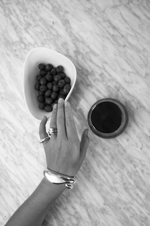 black and white shot of MOUNSER Corn Ring in sterling silver worn on hand showing organic sculptural shape and mirror finish