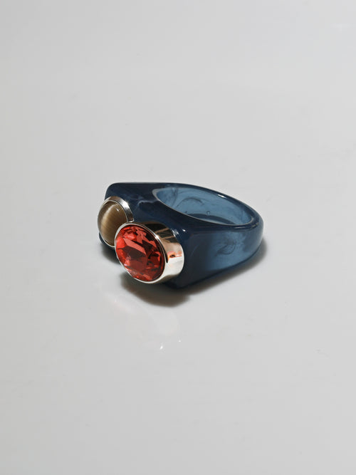 Angle view of MOUNSER Couplet Ring in Denim Blue a jewel toned dual stone ring featuring a Swarovski rhinestone and natural gemstone cabochon on a lucite band