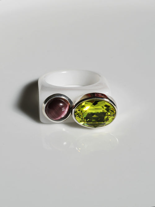 contrast shot of MOUNSER Couplet Ring in Olive a jewel toned dual stone ring featuring a Swarovski rhinestone and natural gemstone cabochon on a lucite band.