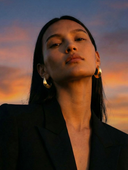 Sunset shot of MOUNSER Crescent Hoops essential sculptural gold hoop earrings
