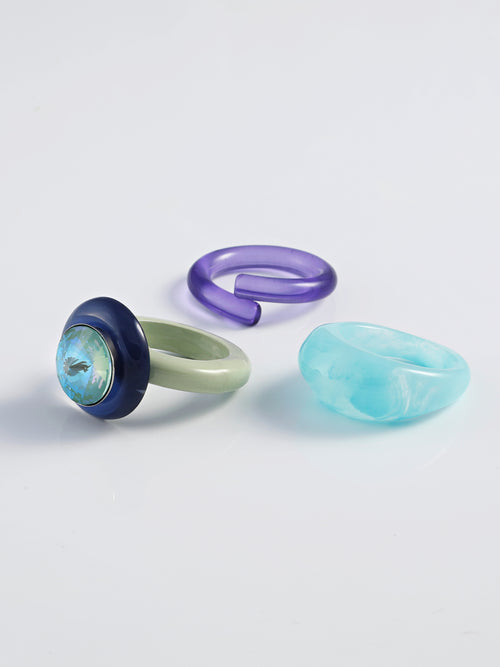 Angel shot of MOUNSER Electric Disco Ring Set in Celestial Fern, a curated trio of stackable resin rings, anchored by a focal with with a sparkling circular Austrian crystal gem