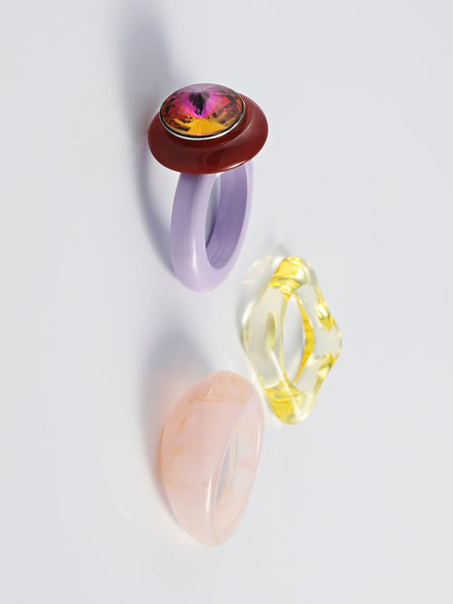 Angel shot of MOUNSER Electric Disco Ring Set in Twilight Plum, a curated trio of stackable resin rings, anchored by a focal with with a sparkling circular Austrian crystal gem