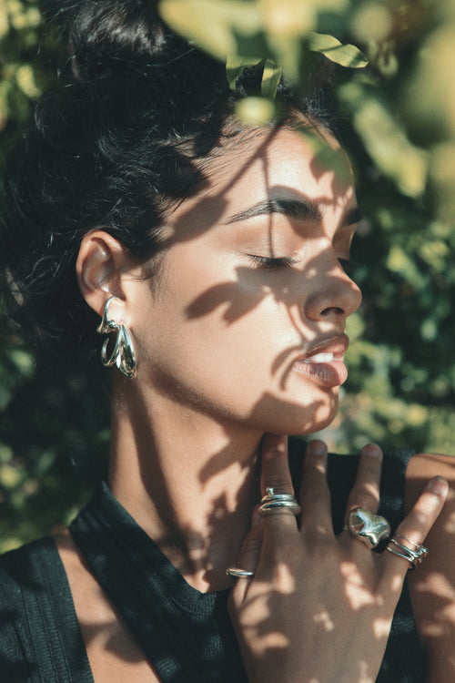 close up shot of MOUNSER Large Blue Hoop Earrings in Sterling Silver sculptural free-form earrings designed as a single style with the illusion of multiple stacked piercings