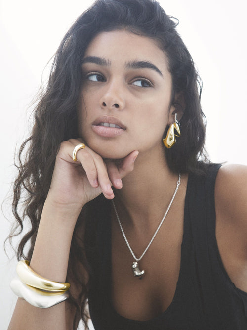 close up shot of MOUNSER Large Egg Earrings in Sterling Silver & Gold Vermeil, handcrafted sculptural free form egg shape earrings with a mirror polish.