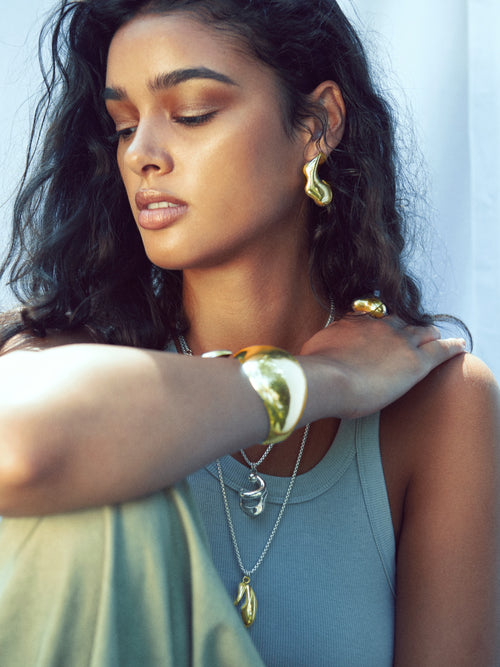 close up model shot of MOUNSER Large Rose Hoop Earrings in Sterling Silver and gold vermeil, handcrafted sculptural free form earrings with a mirror polish