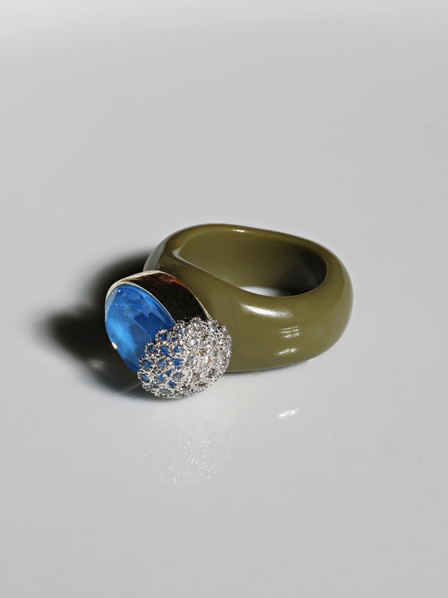 angle shot of MOUNSER Nest Ring in Mirage featuring a brilliant Swarovski crystal, pavé rhinestone detailing and colorful acrylic resin ring band.