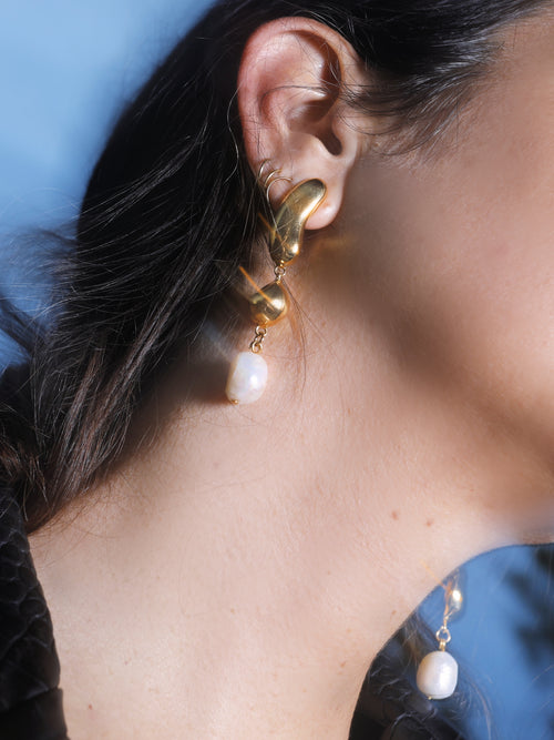 angle shot of MOUNSER Oceanus Earrings in Gold sculptural gold drop earrings with freshwater pearl accents 