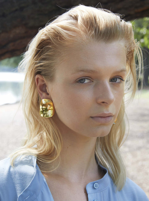 model shot of MOUNSER Peel Earrings in Gold sculptural statement wave shaped earring