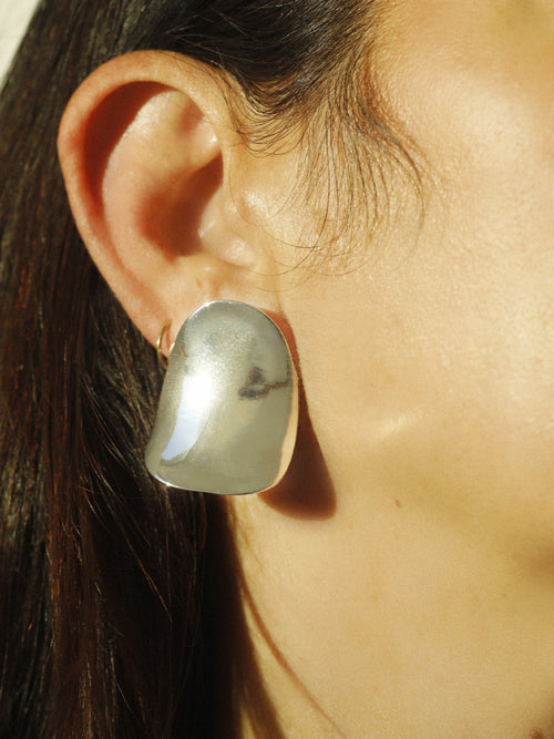 detail shot of MOUNSER Peel Earrings in Silver sculptural statement wave shaped earring