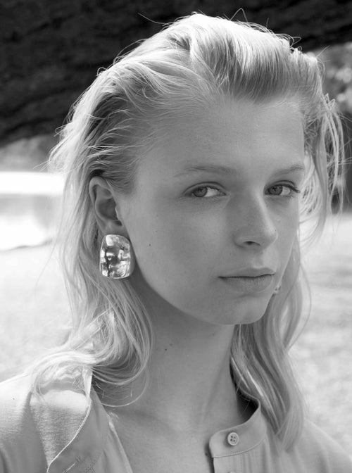 model shot of MOUNSER Peel Earrings in Silver sculptural statement wave shaped earring