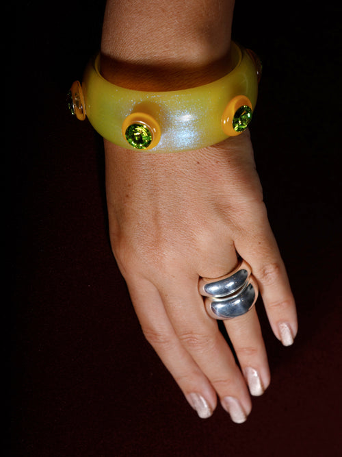 MOUNSER Ambrosia Bangle in Yuzu worn on wrist, showcasing its sculptural form and bold minimalist design.