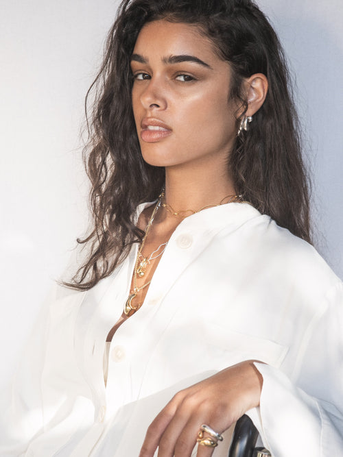 close up shot of MOUNSER Small Ice Moon Hoop Earrings in Sterling silver, a sculptural free-form earring designed as a single style with the illusion of multiple stacked piercings.