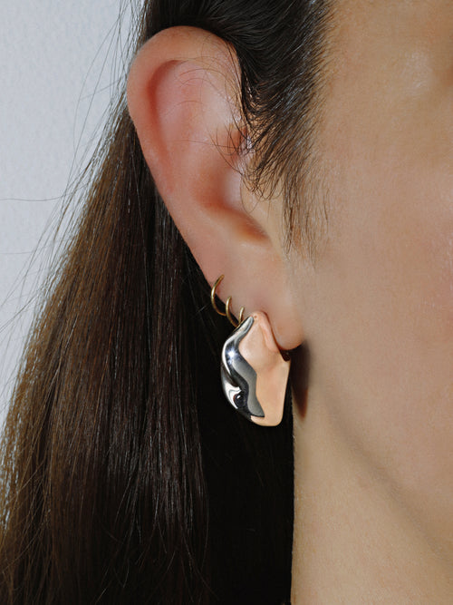 profile shot of MOUNSER Storm Earrings in Sterling Silver with a high polished mirror finish and sculptural puffy stud shape
