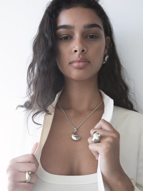 studio shot of MOUNSER Storm Ring in sterling silver worn on model showing organic sculptural shape and mirror finish