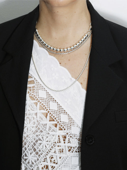detail shot of MOUNSER XO Chain Necklace in Sterling Silver asymmetric chain necklace that balances delicate wheat chain and silver ball bead chain through trompe l'oeil design
