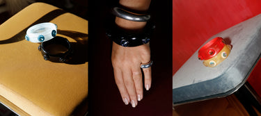 Three styled shots of MOUNSER Ambrosia Sculptural Resin Bangles in blue, black, red and yellow colorways with Swarovski Austrian crystal gemstone studs, shown on a tan leather surface, worn stacked on wrist with sterling silver ring, and resting on a chrome chair against a red background, handcrafted art object jewelry made in Los Angeles.