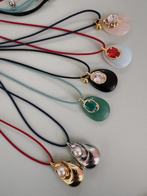 MOUNSER Nereid Necklace Collection displayed in multiple colorways including rose quartz, blue, green, black and red on twisted silk cords in navy, red, black and teal, handcrafted art object jewelry made in Los Angeles.