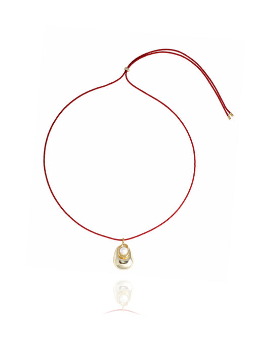 MOUNSER Tide Pool Necklace featuring a sculptural 14k gold-plated brass freeform puffed pendant with freshwater pearl on adjustable crimson twisted silk cord, shown on white background.