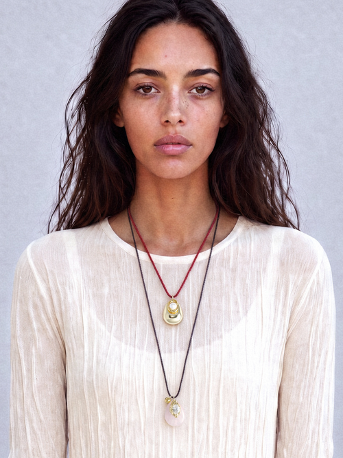 Model wearing MOUNSER Tide Pool Necklace with sculptural gold-plated brass freshwater pearl pendant on crimson twisted silk cord.