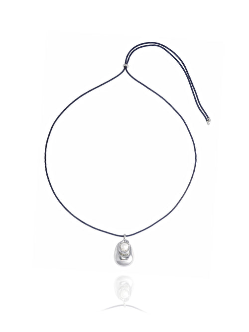 MOUNSER Tide Pool Necklace featuring a sculptural rhodium-plated brass freeform puffed pendant with freshwater pearl on adjustable crimson twisted silk cord, shown on white background.