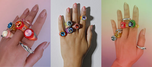 Three hand shots in candy colored rings.  Mounser colorful crystal resin rings with rainbow Swarovski gems.