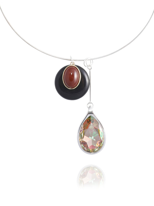 Close-up detail of the MOUNSER Rega Collar Necklace in Caviar showing the stacked obsidian and bordeaux amethyst dome pendant above an elongated Austrian crystal teardrop in rhodium-plated brass setting, with reflection.