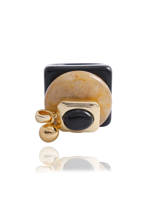 MOUNSER Rizzo Ring in Caramel, featuring a glossy opaque black acrylic resin band, oversized caramel jade disc, 14k gold-plated brass setting with obsidian oval, and petite orb charm, on white background.