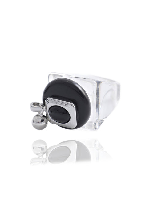 Side angle detail of the MOUNSER Rizzo Ring in Ink Lacquer showing the rhodium-plated brass orb charms, obsidian oval element, and clear acrylic resin band with reflection.