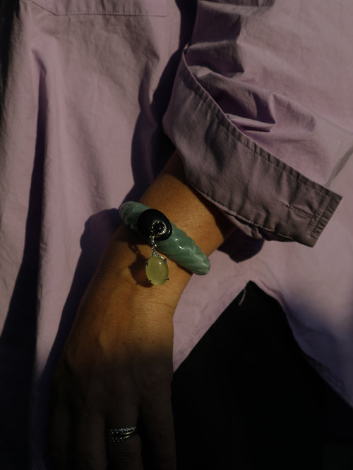 Close-up of the Scallop Drop Cuff in Sea Foam on the wrist, showing the tapered scallop-shell silhouette in sea foam green resin with 14k gold-plated brass details