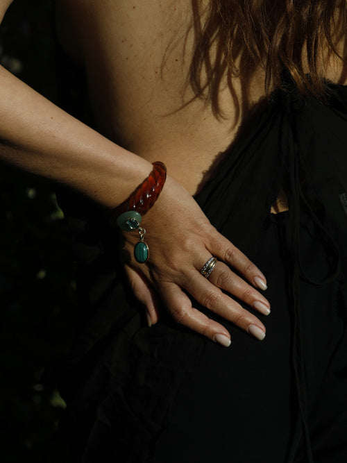 Woman wearing the Scallop Drop Cuff in Tortoise Shell, a sculptural resin bracelet with milky calico finish, aventurine disc, and oversized malachite drop