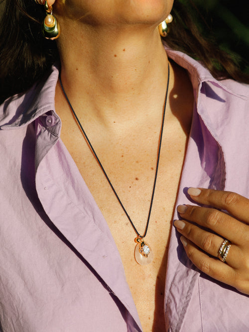 Close-up of MOUNSER Tide Pool Earrings worn on the ear, showing the freshwater pearl nestled within the sculptural gold drop