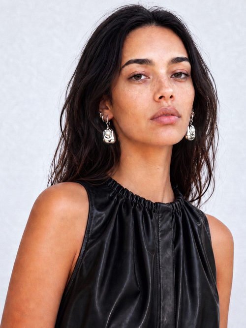 Woman wearing MOUNSER Tide Pool Earrings, sculptural free form silver freshwater pearl drop earrings on a huggie hoop, from the Seascape Abstracted Collection