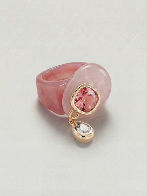 MOUNSER Caspian Ring in Conch Pink - pink rose quartz resin ring with deep pink Austrian crystal and cubic zirconia teardrop charm in 14k gold-plated setting on neutral background