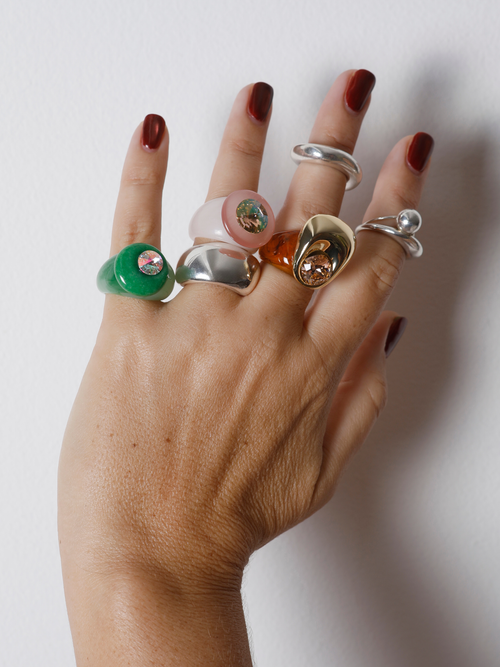 Hand wearing the MOUNSER Mylar Ring in Gold on the finger, showing the chrome statement ring’s size and scale.
