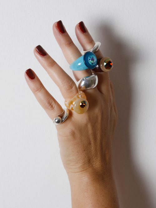 Close-up of the MOUNSER Orbital Ring in Silica on hand: yellow jade disc pierced with a mini faceted crystal moon.