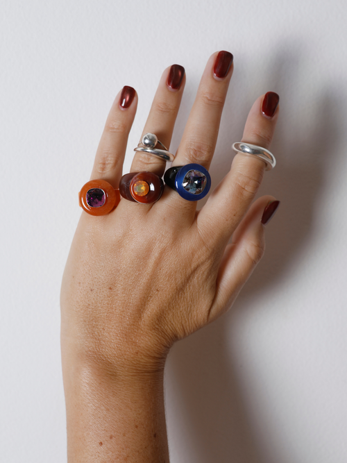 MOUNSER Orbital Ring in Terra worn with ring stack, styling a burgundy and orange gemstone ring.