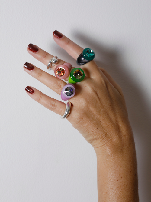 Close-up of the MOUNSER Ring Pop in Mesclun on hand: iridescent yellow Austrian crystal on a glossy green resin band.