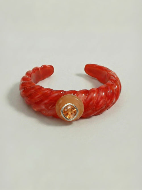 MOUNSER Scallop Cuff in Papaya - orange red sculptural tapered resin open cuff bracelet with yellow jade disc and citrus orange Austrian crystal in rhodium-plated hammered setting on neutral background