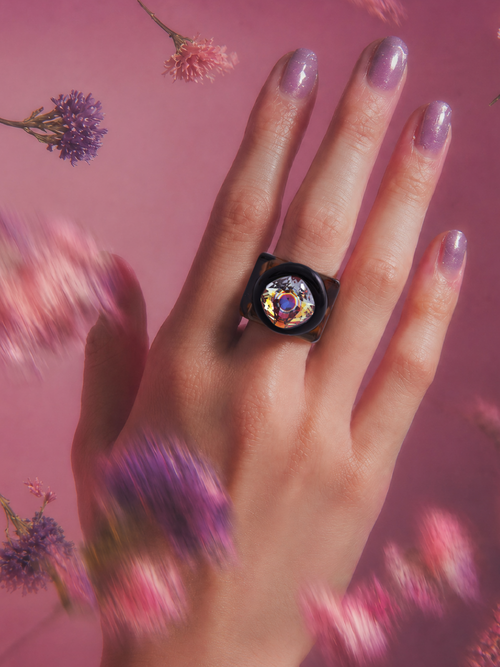 MOUNSER Spectrum Ring in Brunette worn on model's hand — milky brown limited edition cocktail ring with iridescent Austrian crystal on a dark purple floral background, art object jewelry handcrafted to order in Los Angeles.