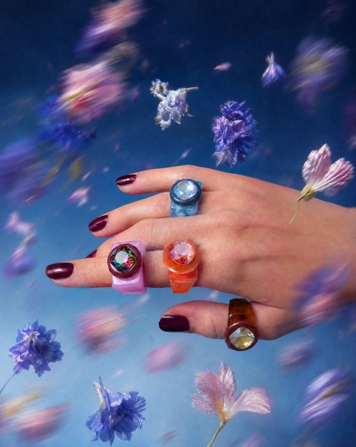 MOUNSER Spectrum Ring in Dark n Stormy worn on model's hand — milky brown limited edition cocktail ring with iridescent Austrian crystal on a blue floral background,  art object jewelry handcrafted to order in Los Angeles.