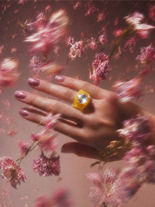 MOUNSER Spectrum Ring in Giorgio worn on model's hand — milky yellow limited edition cocktail ring with iridescent Austrian crystal on a dark purple floral background,  art object jewelry handcrafted to order in Los Angeles.