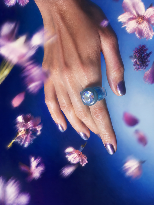 MOUNSER Spectrum Ring in Sleeping Beauty worn on model's hand — milky blue limited edition cocktail ring with iridescent Austrian crystal on a blue floral background,  art object jewelry handcrafted to order in Los Angeles.