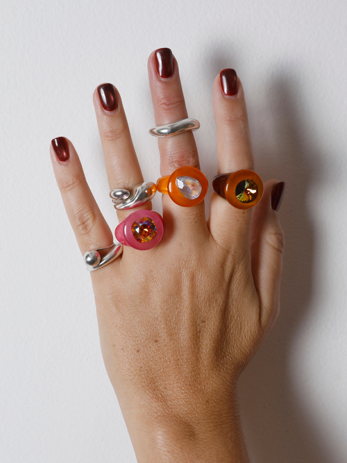 Close-up of the MOUNSER Tears of Joy Ring in Fresh Squeezed on hand: faceted orange pear-shaped Austrian crystal set off-center.