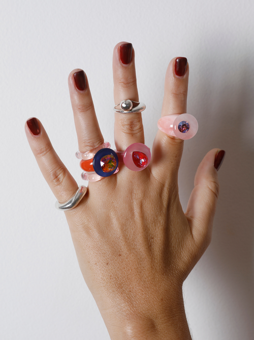 Close-up of the MOUNSER Tears of Joy Ring in Heat Wave on hand: faceted pink pear-shaped Austrian crystal set off-center.