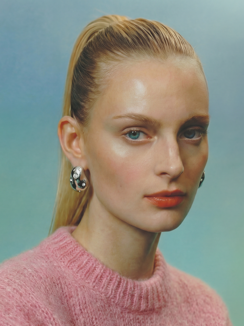 kidney bean shaped sculptural silver earrings with rhinestones.